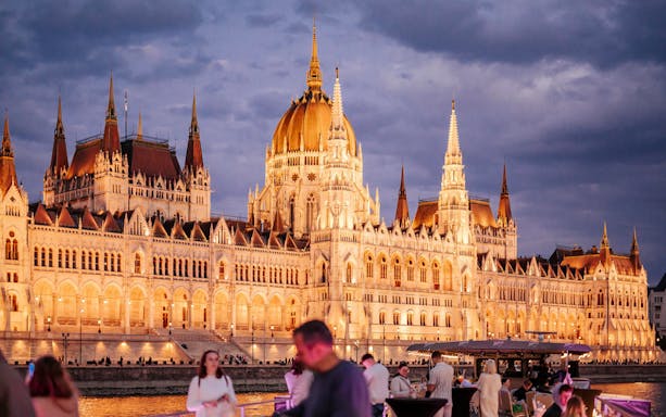Guests enjoying views of the illuminated Hungarian Parliament during Budapest Danube River Floating Beerfest.