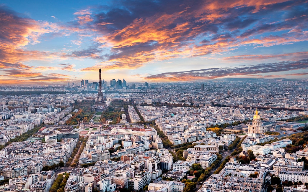 Aerial view of Paris skyline from Montparnasse Tower, featuring Eiffel Tower and Les Invalides.