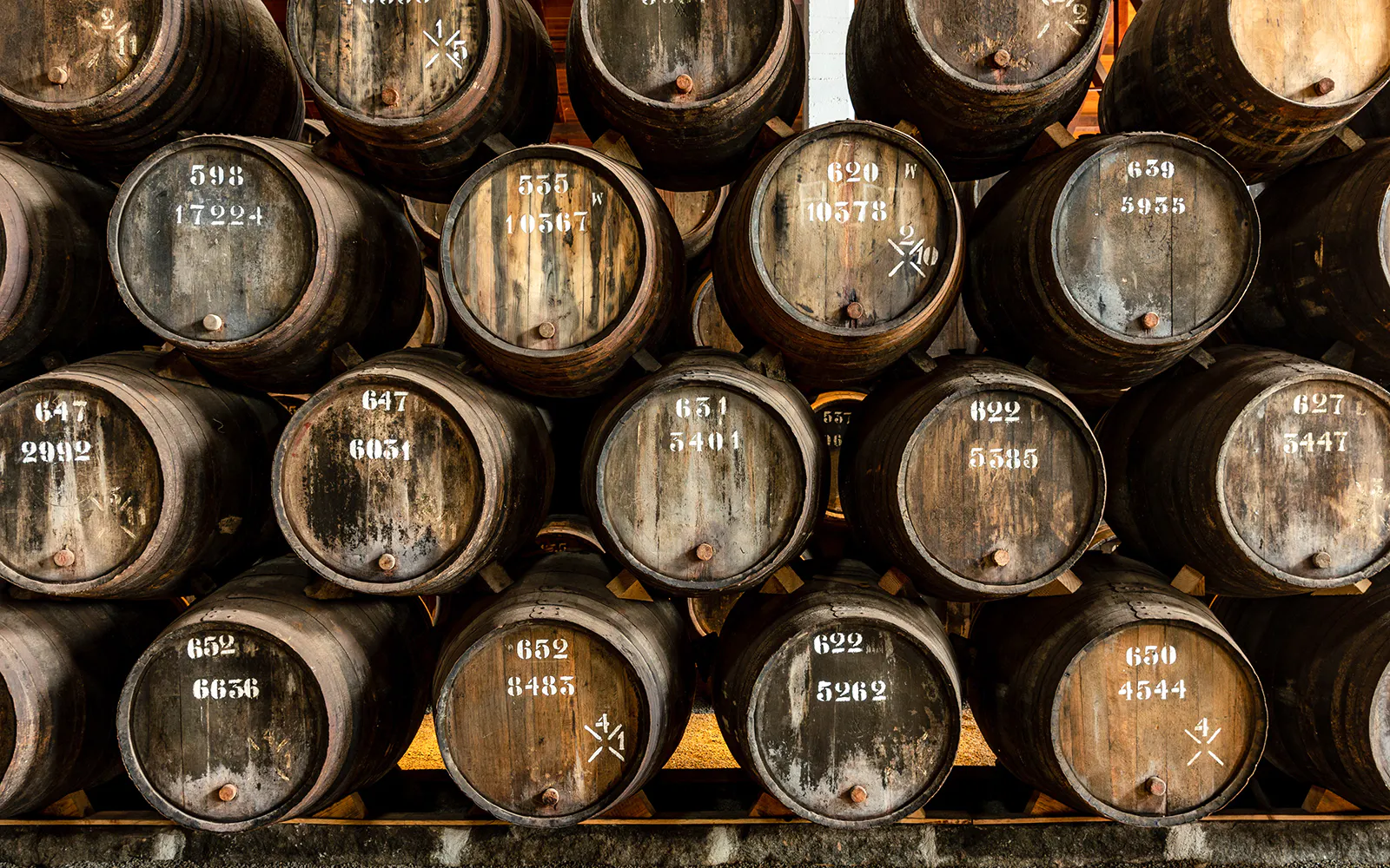 Stacked oak barrels at Taylor's Port Cellars in Porto.