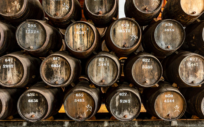 Stacked oak barrels at Taylor's Port Cellars in Porto.
