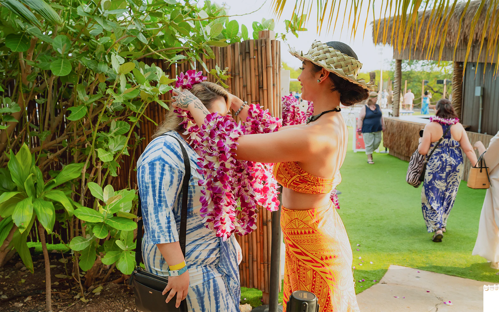 Woman placing flower lei on guest at Mauka Warriors Luau.