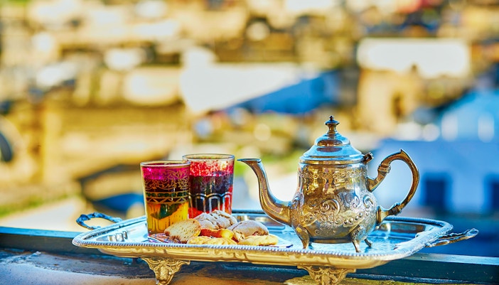 Silver teapot and glasses with pastries on a tray, Traditional Treatment Hammam & Spa.