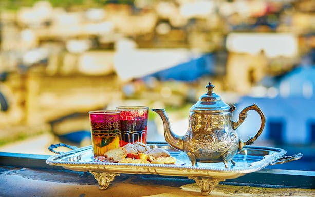 Silver teapot and glasses with pastries on a tray, Traditional Treatment Hammam & Spa.