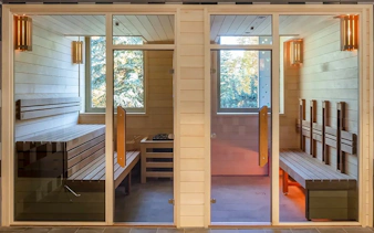 Sauna rooms at Pesterzsebet Bath, Budapest with wooden benches and glass doors.