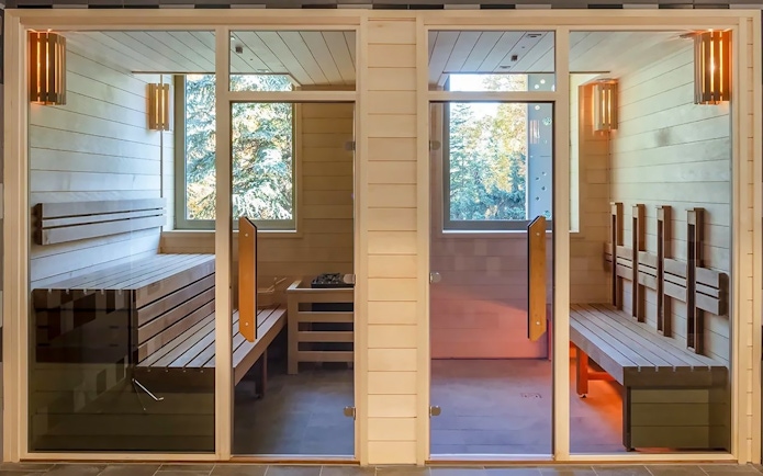 Sauna rooms at Pesterzsebet Bath, Budapest with wooden benches and glass doors.