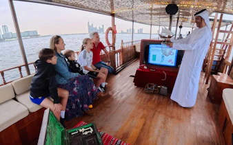 Guests learning about pearl diving on a traditional boat tour in Dubai.
