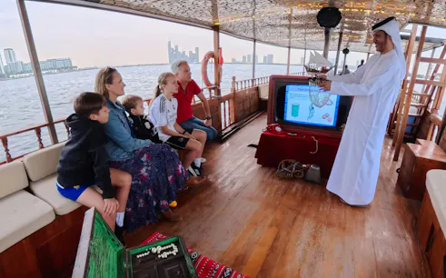 Guests learning about pearl diving on a traditional boat tour in Dubai.
