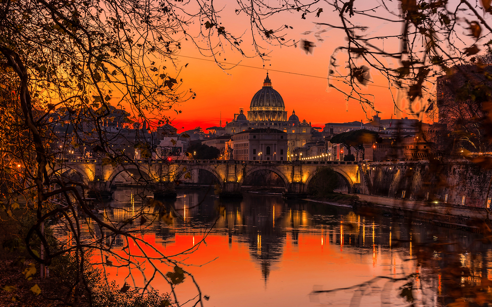 Sunset view of St. Peter's Basilica and Tiber River in Rome during an aperitif cruise.