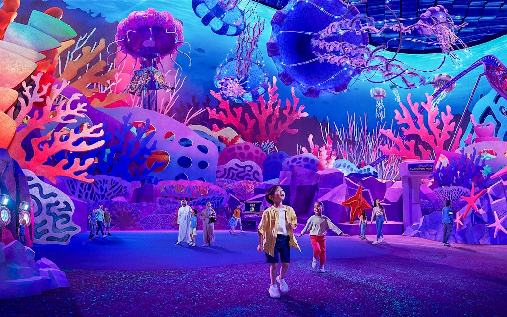 Children exploring vibrant coral displays at Aquarium at the Boardwalk, Sea World Abu Dhabi.