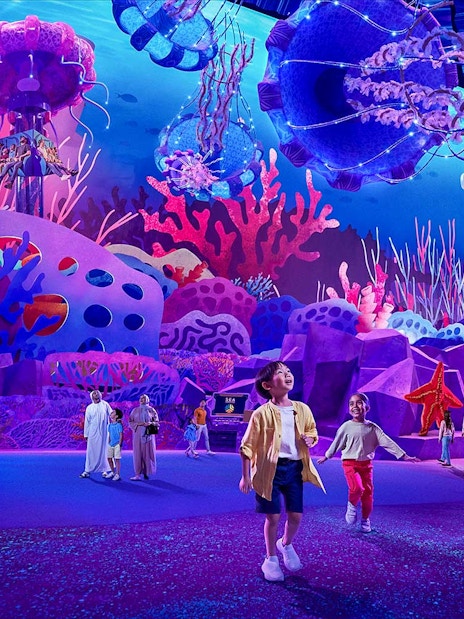Children exploring vibrant coral displays at Aquarium at the Boardwalk, Sea World Abu Dhabi.