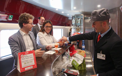 Train passengers enjoying drinks at the bar on an Interrail Global Mobile Pass journey.