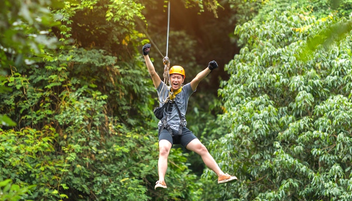 Visitors climbing the ESCAPE Penang Flying Lemur in Malaysia, showcasing the adventure park's unique vertical challenge.