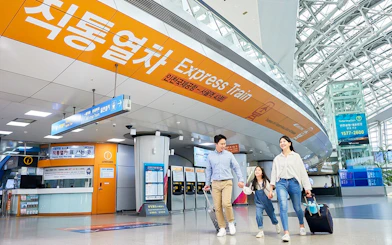 Family walking in Incheon Airport towards AREX Express Train to Seoul.