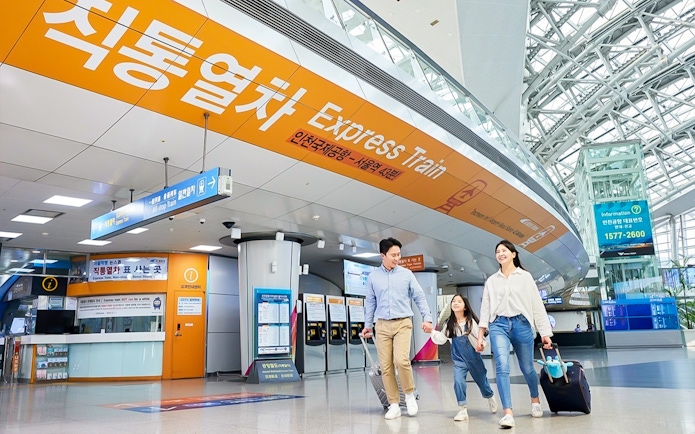 Family walking in Incheon Airport towards AREX Express Train to Seoul.