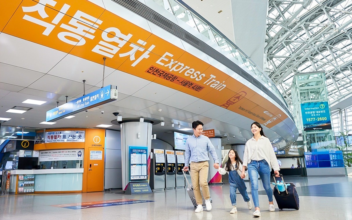 Family walking in Incheon Airport towards AREX Express Train to Seoul.