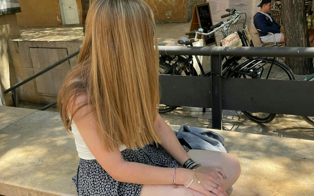Person sitting on a bench near bicycles in Valencia during a self-guided city exploration game.