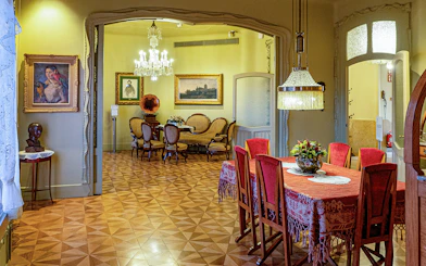 La Pedrera Casa Mila dining room with ornate chandelier and vintage furniture.