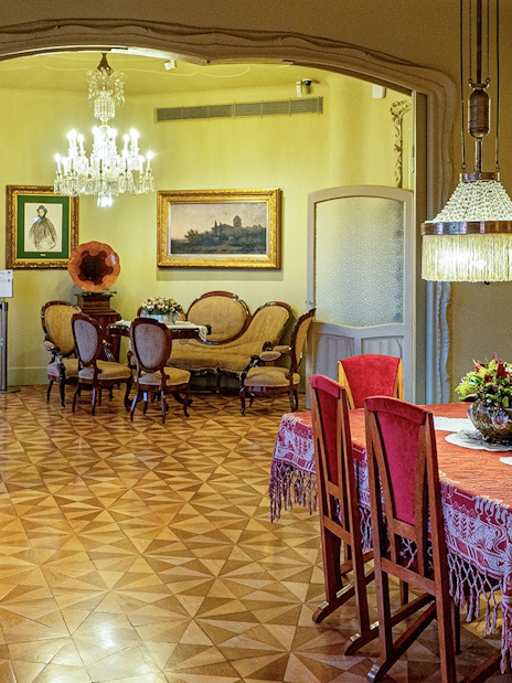 La Pedrera Casa Mila dining room with ornate chandelier and vintage furniture.