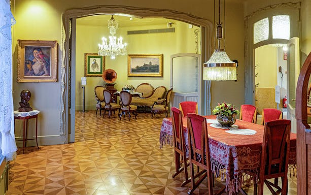 La Pedrera Casa Mila dining room with ornate chandelier and vintage furniture.