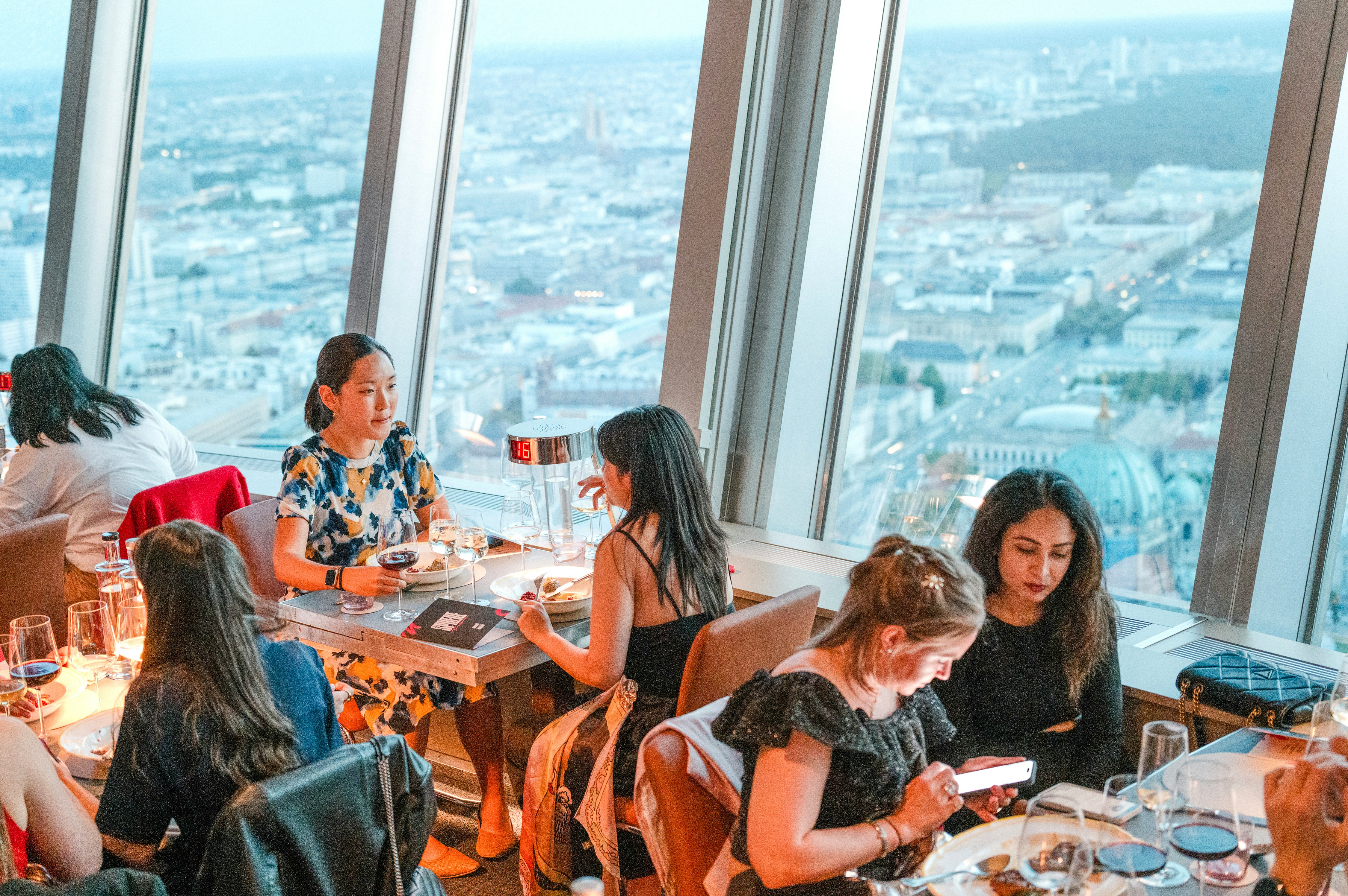 Guests dining at the Berlin TV Tower restaurant with city views.