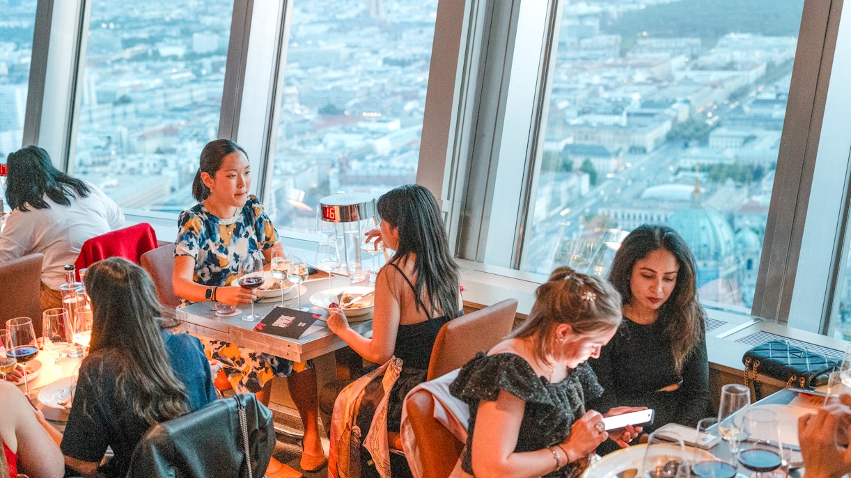 Guests dining at the Berlin TV Tower restaurant with city views.