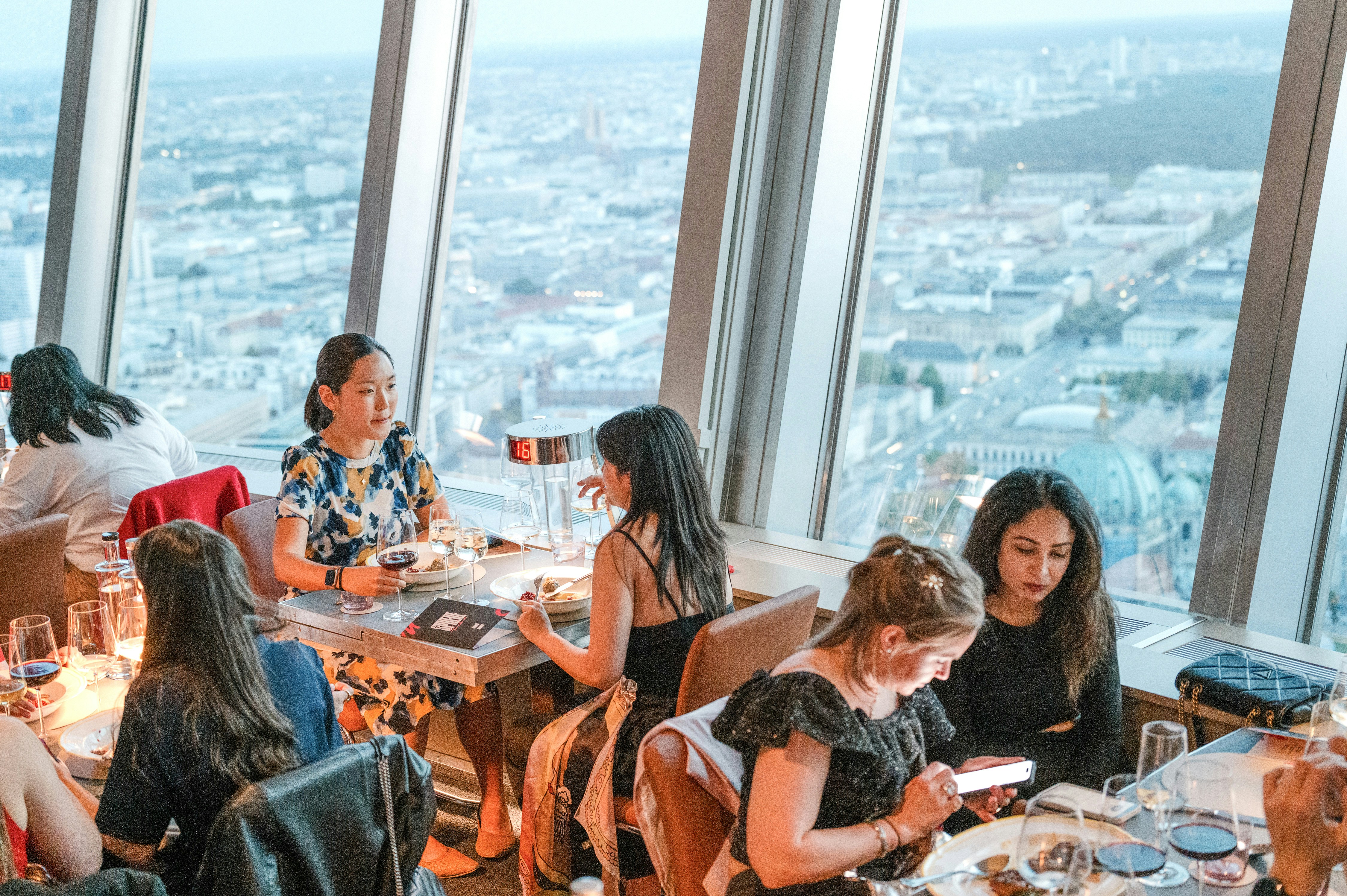 Guests dining at the Berlin TV Tower restaurant with city views.