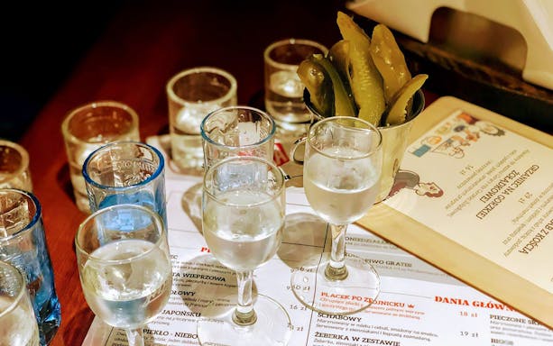 Vodka glasses and pickles on a table during a tasting tour in Wroclaw.