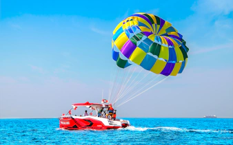Parasailing adventure over the Arabian Gulf in Dubai with colorful parachute.