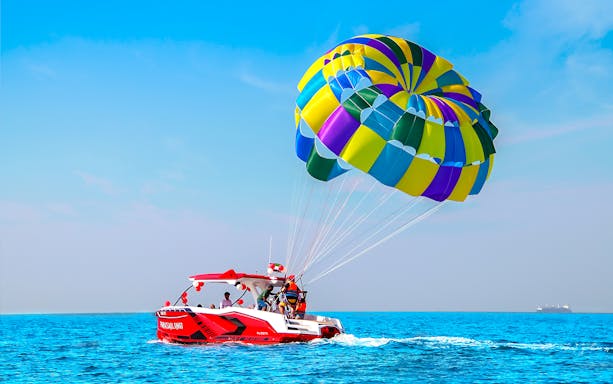 Parasailing adventure over the Arabian Gulf in Dubai with colorful parachute.