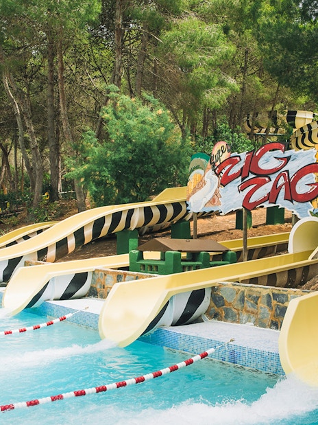 Zig Zag water slides at Aqualandia Benidorm surrounded by trees.