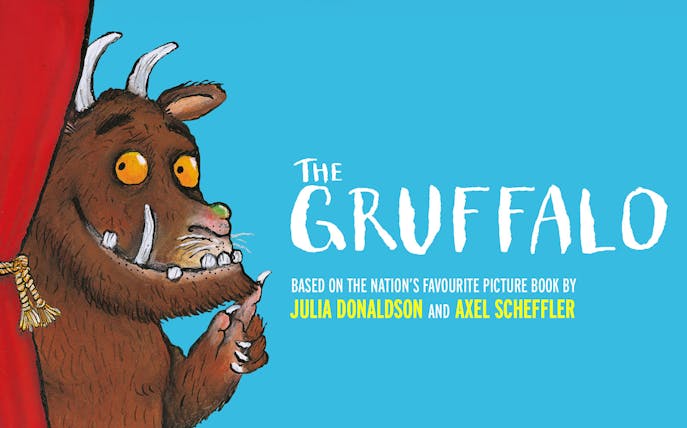 Gruffalo character peeking from red curtain, promoting West End show.
