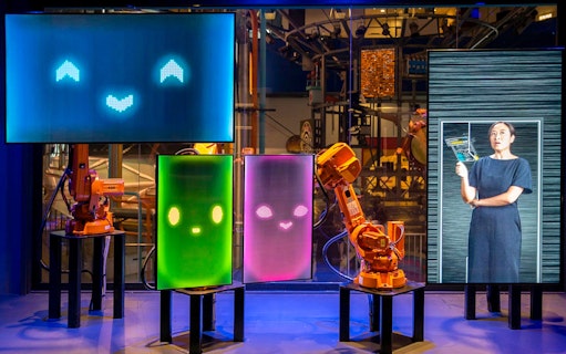 Interactive robot exhibit at Science Centre Singapore with digital screens and robotic arms.