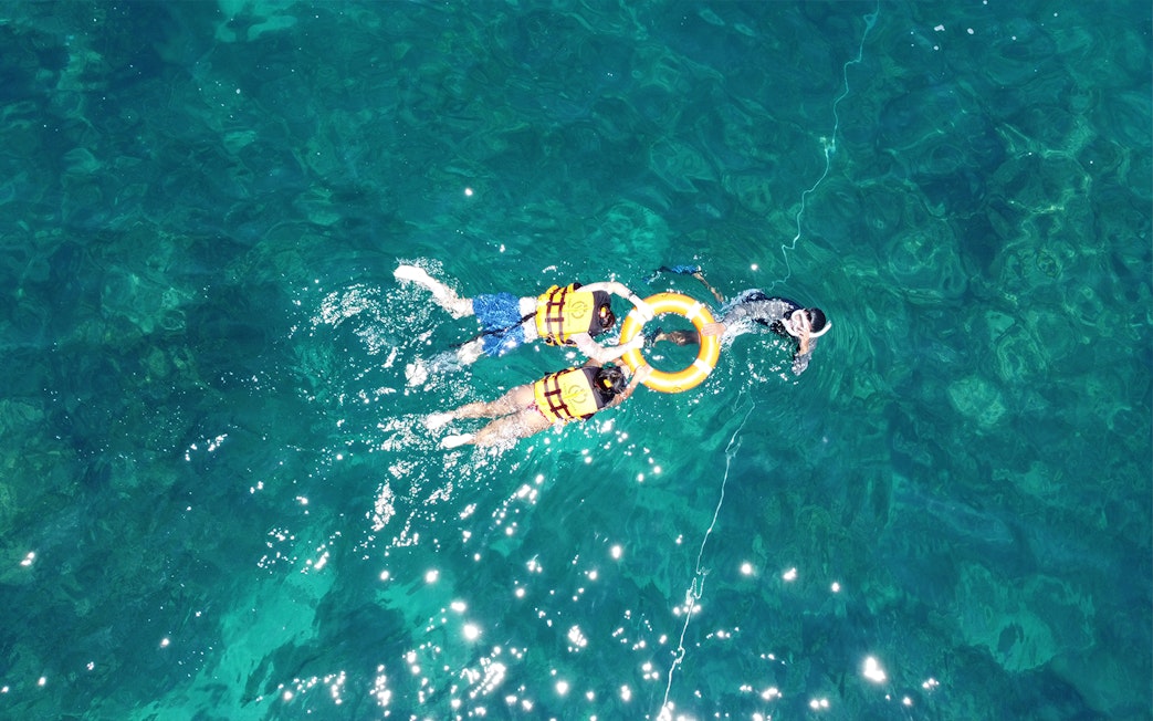 Snorkelers in life vests exploring clear waters near Phi Phi.