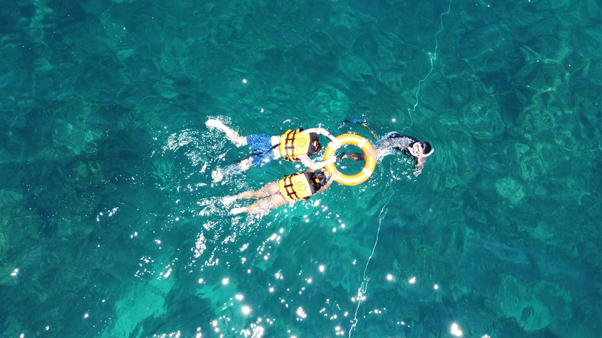 Snorkelers in life vests exploring clear waters near Phi Phi.
