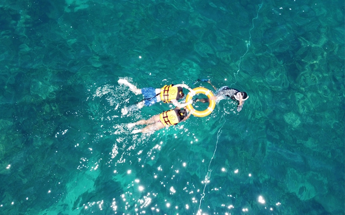 Snorkelers in life vests exploring clear waters near Phi Phi.