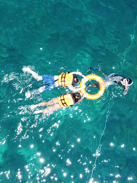 Snorkelers in life vests exploring clear waters near Phi Phi.