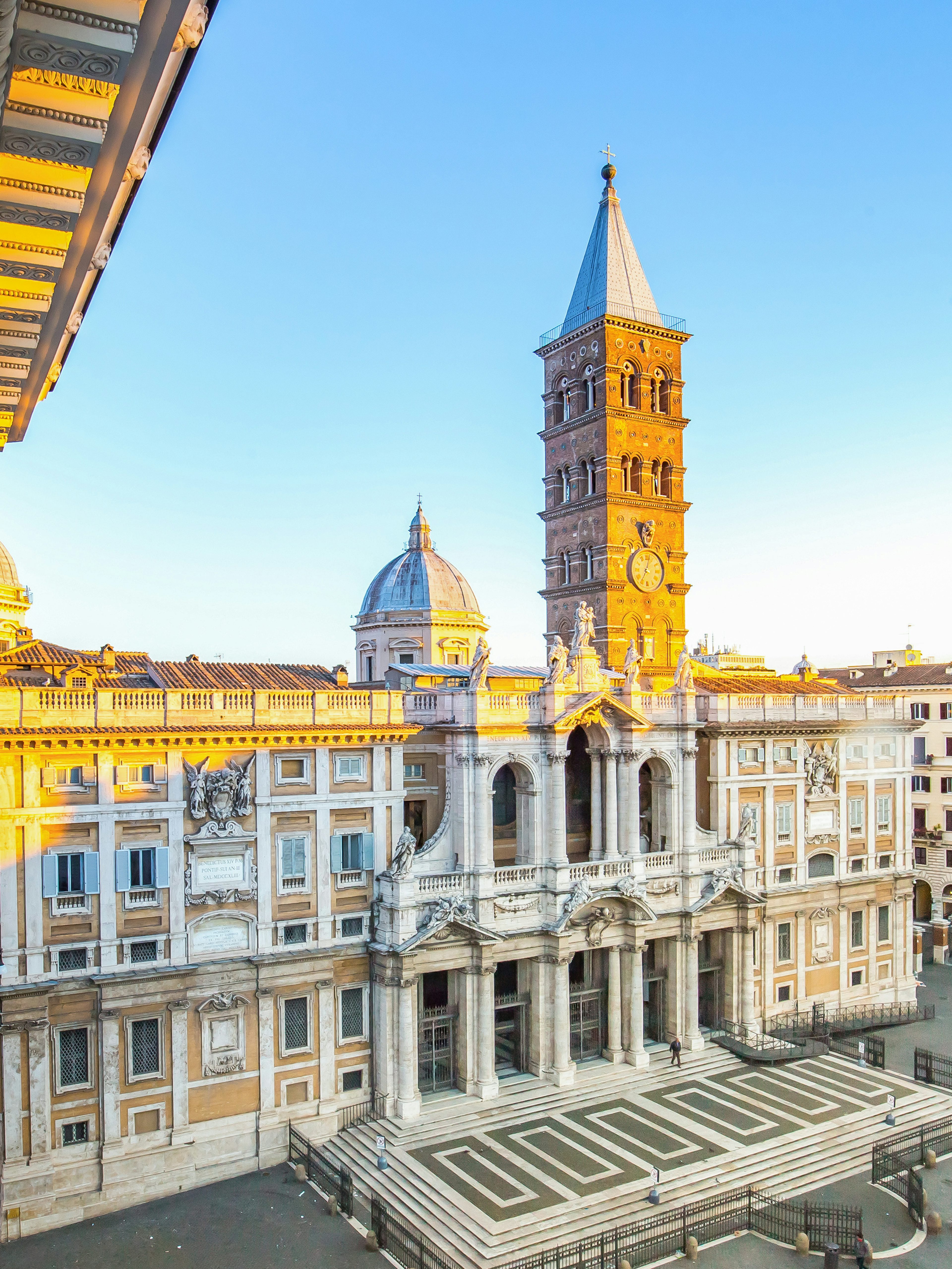 Santa Maria Maggiore facade in Rome with bell tower and surrounding buildings.