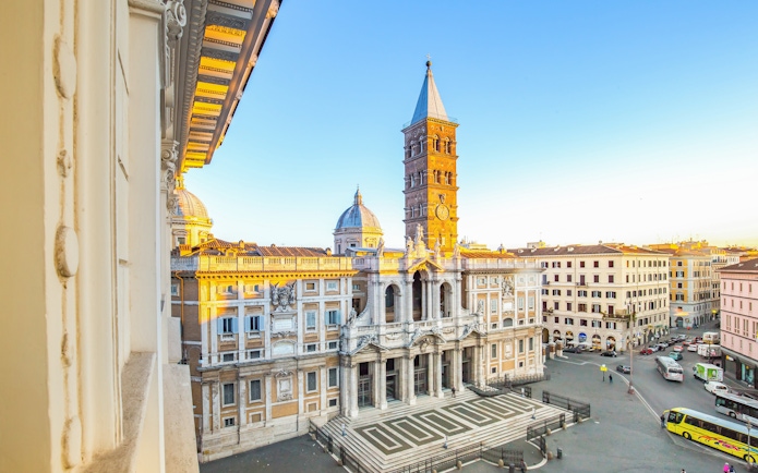 Santa Maria Maggiore facade in Rome with bell tower and surrounding buildings.