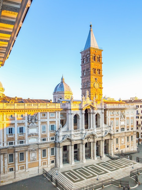 Santa Maria Maggiore facade in Rome with bell tower and surrounding buildings.