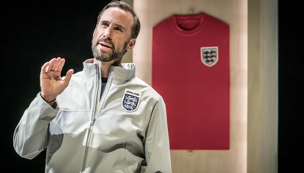 Man in England jacket speaking with red England jersey in background.