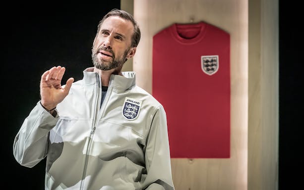 Man in England jacket speaking with red England jersey in background.