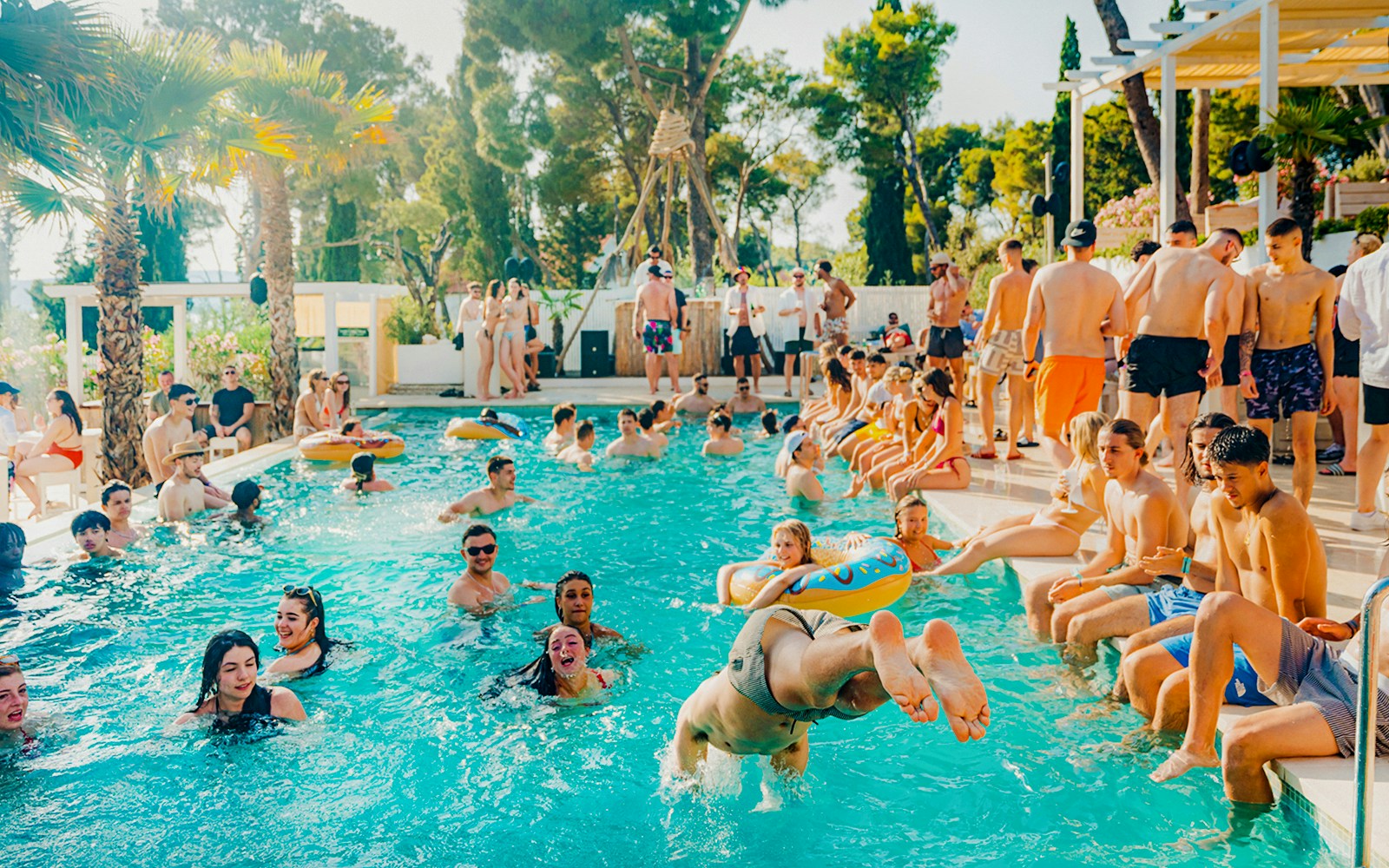 Guests swimming and relaxing at Olife Beach Club pool.