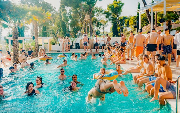 Guests swimming and relaxing at Olife Beach Club pool.