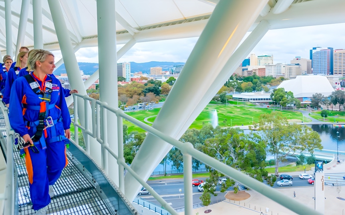Adelaide Oval rooftop climbers with cityscape and park view.