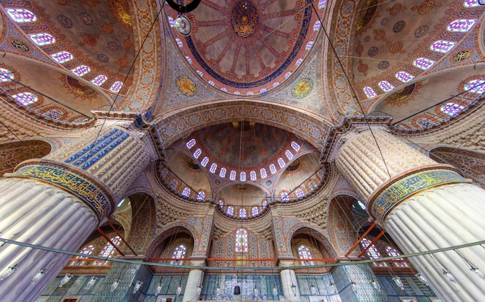 Interior view of The Blue Mosque's ornate dome and columns in Istanbul, Turkey.