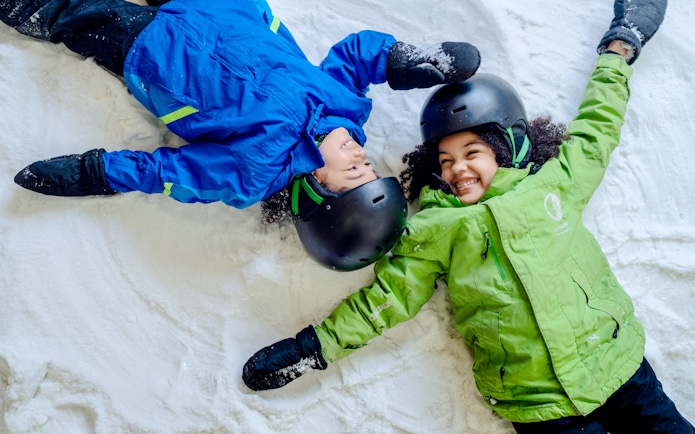 Children making snow angels at Big Snow American Dream.