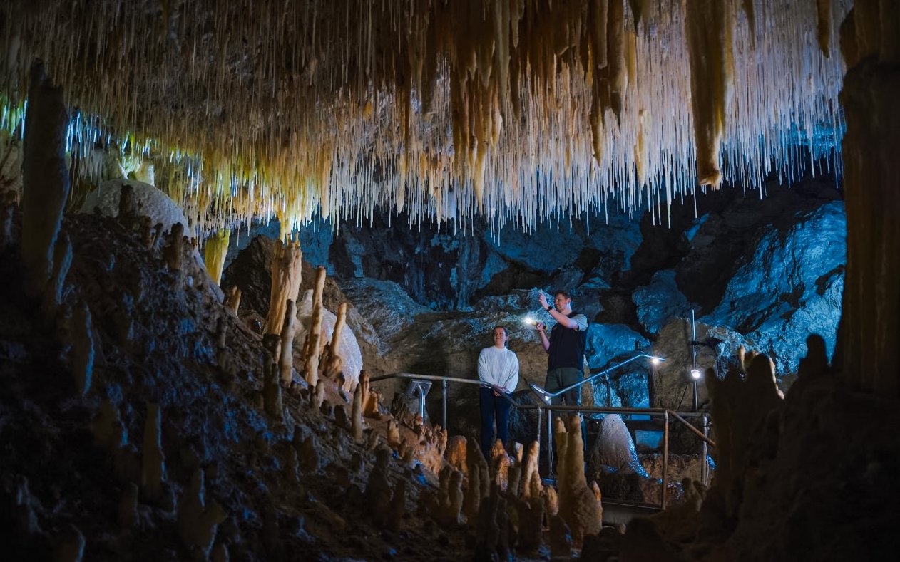 Visitors exploring stalactites in Margaret River Caves, Australia.