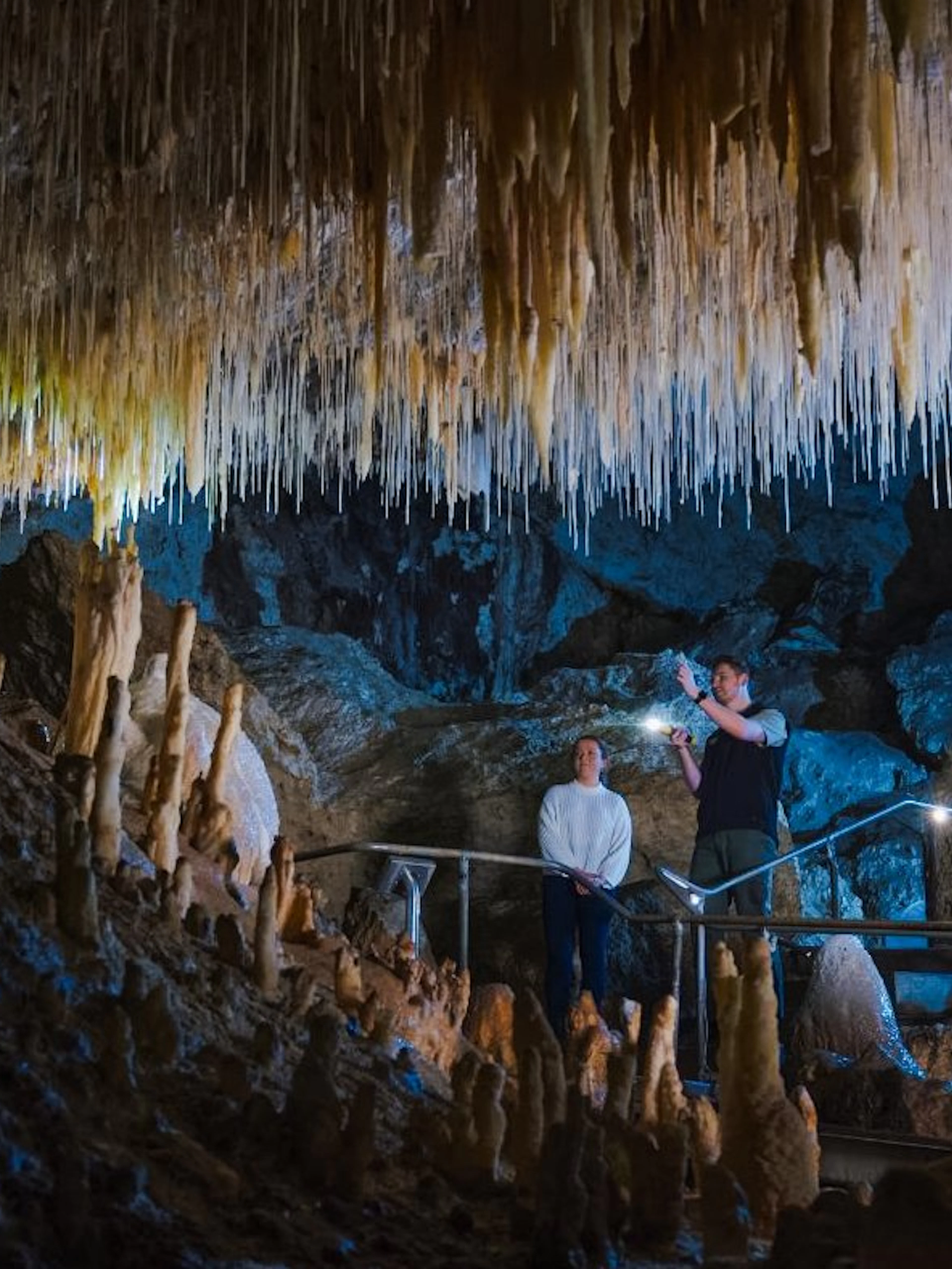 Visitors exploring stalactites in Margaret River Caves, Australia.