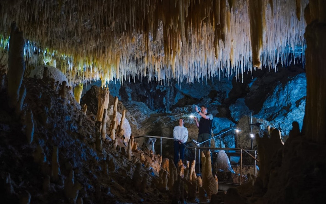 Visitors exploring stalactites in Margaret River Caves, Australia.