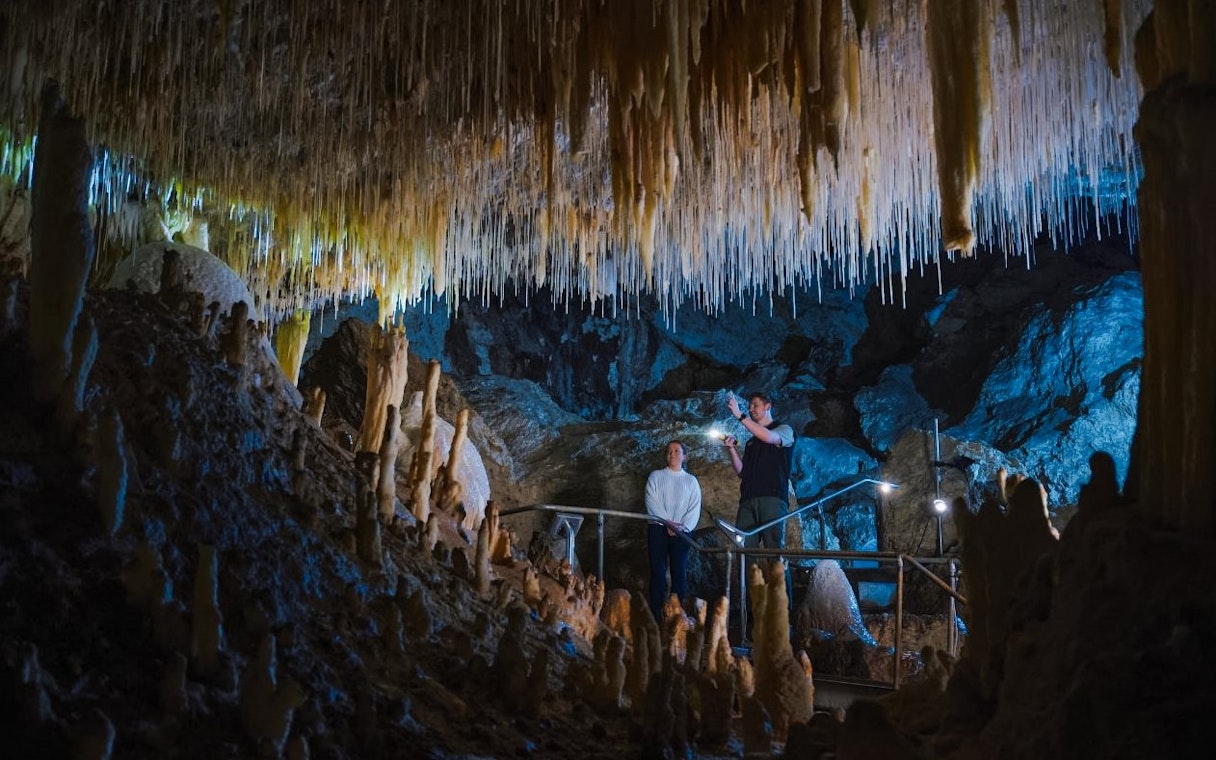 Visitors exploring stalactites in Margaret River Caves, Australia.